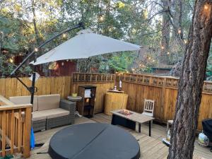 a patio with a table and an umbrella at Sugar Suites Cozy Cabin Retreat Near Big Bear in Sugarloaf