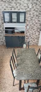 une table et des chaises dans une pièce avec un bureau dans l'établissement Kitnet montanha mágica, à São Thomé das Letras