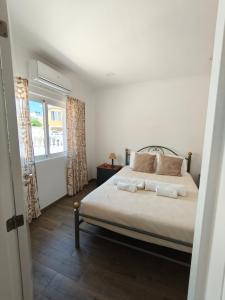 una camera da letto con un letto con due asciugamani sopra di Casa do Poço a Vila Real de Santo António