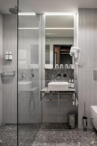 a bathroom with a shower and a sink and a mirror at Hotel Aida in Prague