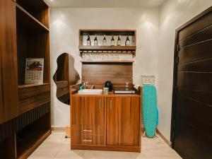 a kitchen with a sink and a shelf with bottles at Résidences Sica in Cotonou