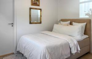 a bed with white sheets and a mirror on the wall at Gorgeous Home In Farsø With Wifi in Gatten +9 photos