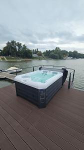 a hot tub sitting on a deck next to the water at Prestige Yacht Resort Budapest in Budapest