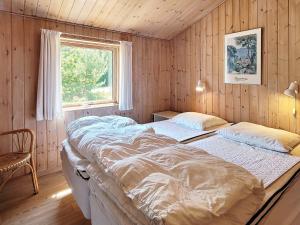- une chambre avec 2 lits dans une chambre avec une fenêtre dans l'établissement 8 person holiday home in Nexø-By Traum, à Snogebæk