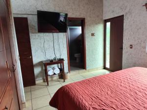 a bedroom with a bed and a television and a mirror at Casa San Javier, La Loma in Tapalpa