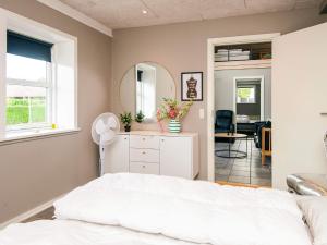 a bedroom with a white bed and a mirror at 4 star holiday home in Henne in Henne +44 photos