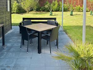 Una mesa y sillas de madera en un patio. en 4 person holiday home in Gilleleje-By Traum, en Gilleleje