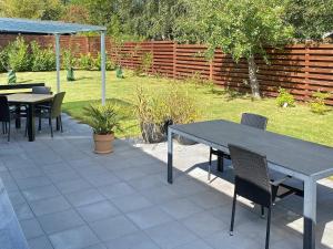 Un patio con mesas y sillas y una valla. en 4 person holiday home in Gilleleje-By Traum, en Gilleleje