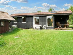 a gray house with a table and chairs in a yard at 6 person holiday home in Fårevejle-By Traum in Fårevejle