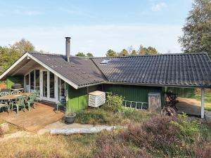 a green house with a deck and a table at 6 person holiday home in Ålbæk-By Traum in Ålbæk