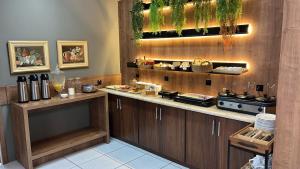 a kitchen with wooden cabinets and a counter with food at Nap Hotel in Ponta Grossa