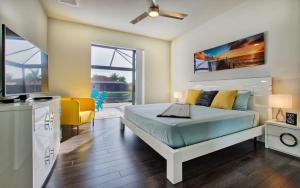 Un dormitorio con una cama, un sofá y un televisor. en Villa White Pearl, en Matlacha