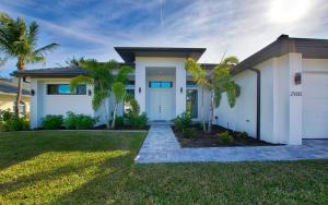 una casa blanca con palmeras delante en Villa White Pearl, en Matlacha