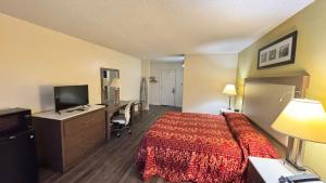 a hotel room with a bed and a desk at Country Host Inn in Franklin +14 photos