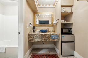 a bathroom with a sink and a mirror at Days Inn & Suites by Wyndham Terre Haute in Terre Haute