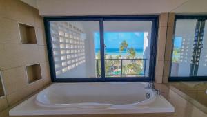モンバサにあるPenthouse with Stunning Beachfront Viewsの窓のある浴室に大きな浴槽がある +29枚の写真