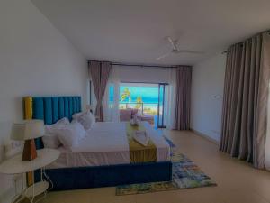 モンバサにあるPenthouse with Stunning Beachfront Viewsの海の見えるベッドのある寝室