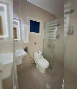 a white bathroom with a toilet and a sink at نايس فيو بانوراما للشقق الفندقية in Al Jubail +44 photos