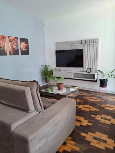 a living room with a couch and a flat screen tv at Quarto cop 30 in Belém