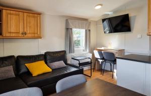 a living room with a black couch and a kitchen at Nice Ship In Göteborg With Sauna in Gothenburg