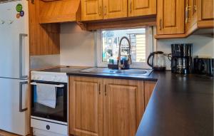 a kitchen with wooden cabinets and a sink and a refrigerator at Nice Ship In Göteborg With Sauna in Gothenburg