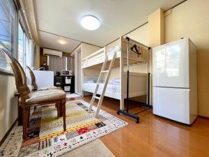 ein Zimmer mit zwei Etagenbetten und einem Stuhl und einem Kühlschrank in der Unterkunft Atami Hotel 101 in Atami
