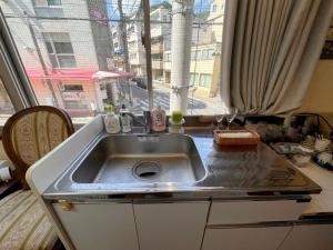 eine Küchenspüle vor einem Fenster in der Unterkunft Atami Hotel 101 in Atami