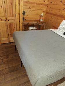 a bedroom with a bed in a wooden room at Cozy Cabin near Dove Ridge Winery and Lake Weatherford in Azle