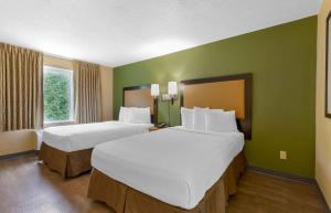 ジェサップにあるExtended Stay America Suites - Columbia - Laurel - Ft Meadeのベッド2台 ホテルルーム 緑の壁 +24枚の写真