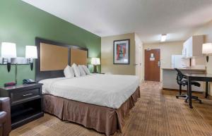 a hotel room with a large bed and a desk at Extended Stay America Suites - Indianapolis - Castleton in Fishers