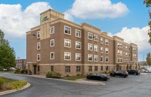 a large brick building with cars parked in a parking lot at Extended Stay America Suites - Detroit - Dearborn in Dearborn