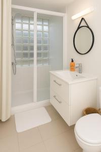 a white bathroom with a shower and a toilet at Le Nid d Abbaye in Caen