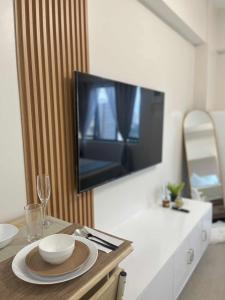 a living room with a table with a tv on the wall at ARA Condotel in Cebu City