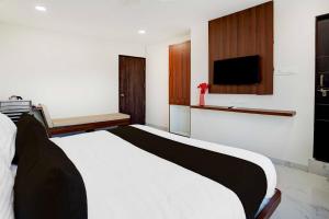 a bedroom with a bed and a tv on the wall at Hotel O Omkar Nagar Nagpur in Nagpur