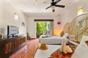 a hotel room with two beds and a flat screen tv at Hotel Riviera Del Sol in Playa del Carmen
