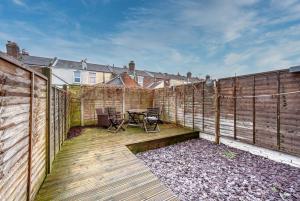 a wooden deck with a table and a fence at Aylesbury House 3 En-suite Bedrooms Parking Pets in Portsmouth