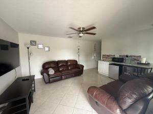 Una sala de estar con un sofá y un ventilador de techo. en Sarasota suites, en Sarasota