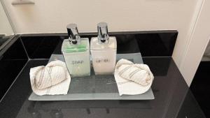 two bottles of soap and towels on a shelf at Carrie The Gentle Nest 1 in Coquitlam +27 photos