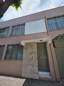 a pink building with a door and a garage at Hostal Genoveva in San Salvador
