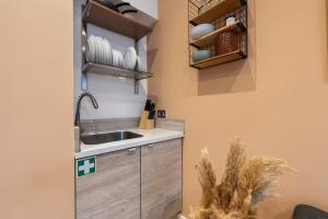 a kitchen with a sink and a shelf with dishes at Aylesbury House 3 En-suite Bedrooms Parking Pets in Portsmouth +45 photos