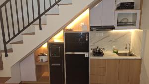 バトゥにあるVilla Almahyra Batuのキッチン(黒い冷蔵庫付)、階段