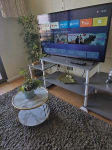 a living room with a tv on a stand with a table at Departamento hermosa vista de la ciudad in Rancagua