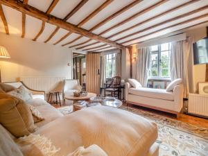 a living room with a couch and a table at All Saints Cottage in Saffron Walden