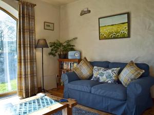 a living room with a blue couch and a table at Barn End Cottage in Millers Dale