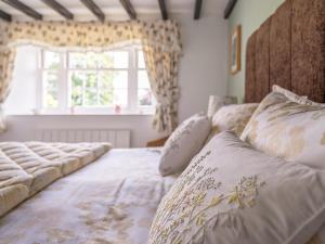 a bedroom with two beds and a window at Garden Cottage in Morland +10 photos