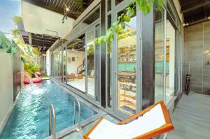 a house with a swimming pool in the middle at Mykhe Beach 10 minutes Free pick-up Breakfast service BBQ Private pool villa in Da Nang