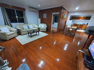 sala de estar con suelo de madera y sala de estar con mesa en Loverly Three Bedroom Rental Pool Outdoor Area Upper, en Suva