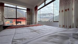 a bedroom with a large bed with a large window at Valle Sagrado in Coya