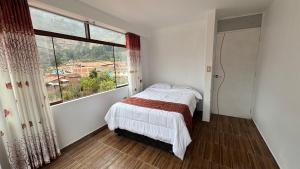 a bedroom with a bed and a large window at Valle Sagrado in Coya