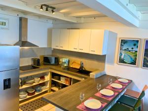 a kitchen with a table with plates on it at Maison Bleu-Oxygène Accès direct au bassin Manapany-Les-Bains in Saint-Joseph +17 photos